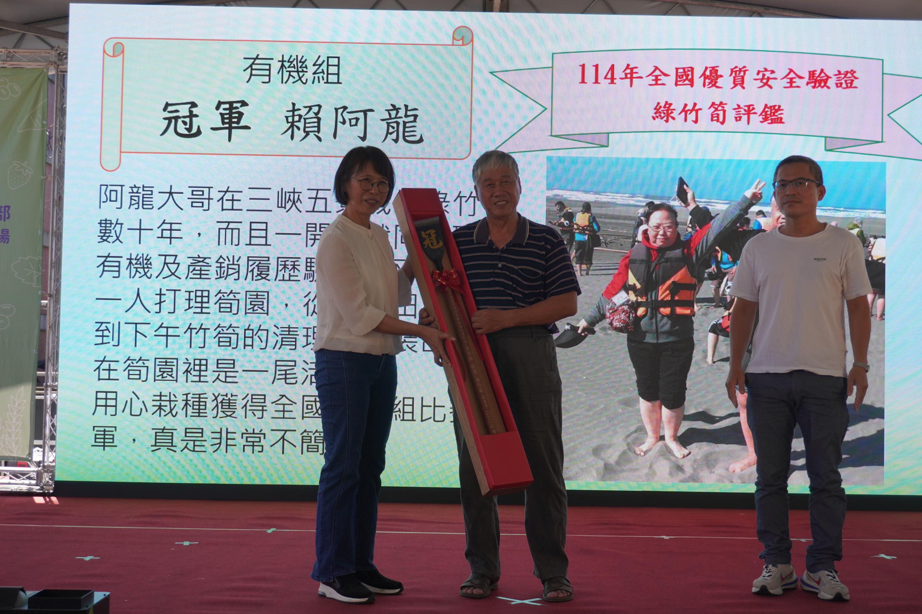 圖4.本場王毓華場長致贈賀匾予賴阿龍先生恭賀榮獲114年全國優質安全驗證綠竹筍評鑑有機組冠軍。