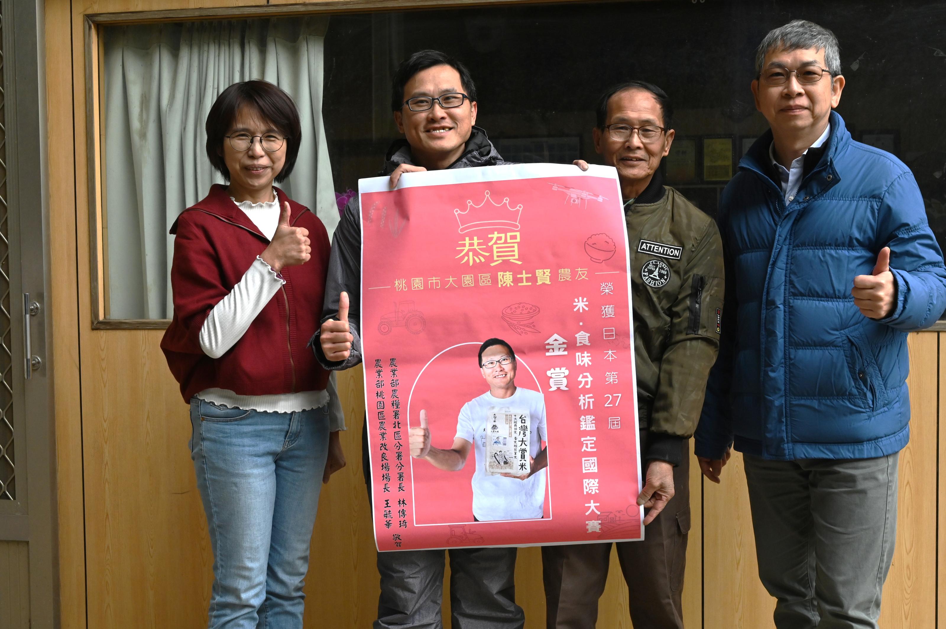 圖2.本場王毓華場長及農糧署北區分署黃怡仁副分署長共同向陳士賢青農獲得日本「米·食味分析鑑定大賽金賞獎」恭賀及貼榜致意。