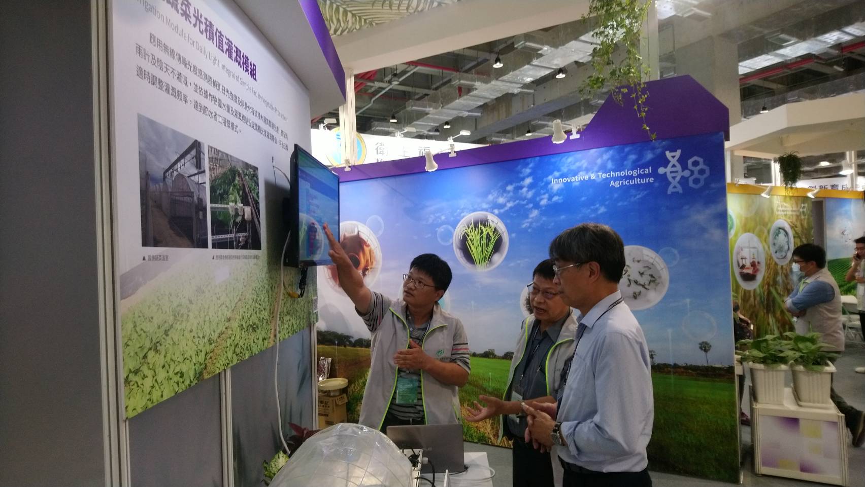 本場展項-賴信忠副研究員(左1)向農委會陳駿季副主委(右1)、王仕賢處長(右2)介紹設施蔬菜光積值灌溉模組。