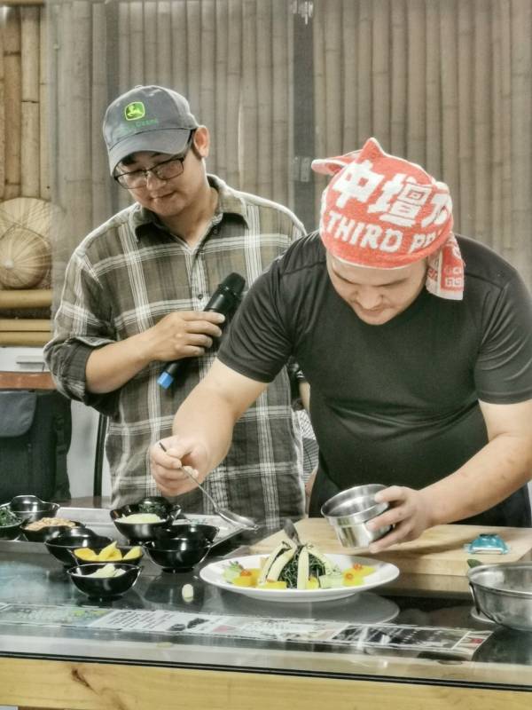 山藥林徐鼎主廚(前)，示範「醋溜昭和菜」，農雅葳農莊的徐榮偉(後)協助解說。