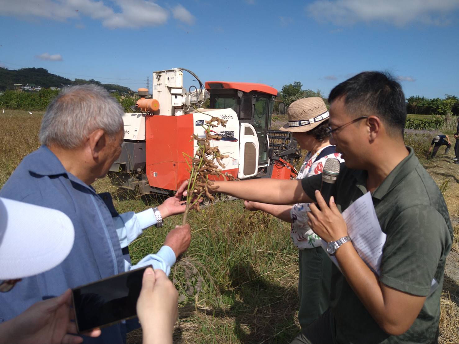 本場林禎祥助理研究員(右1)向農友說明大豆生育特性。
