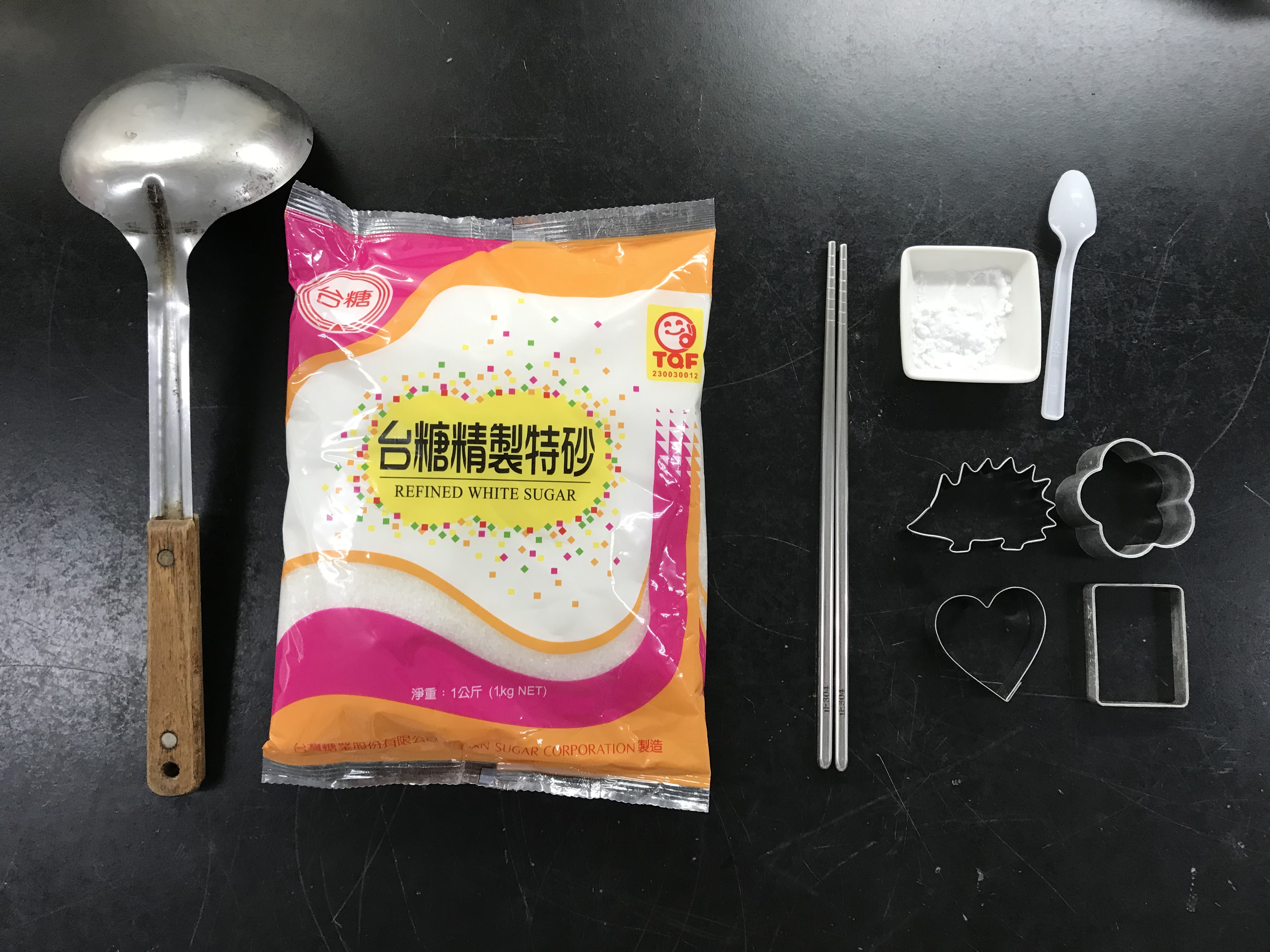 椪糖製作的材料與工具-大湯匙、砂糖、小蘇打粉、筷子、模具。