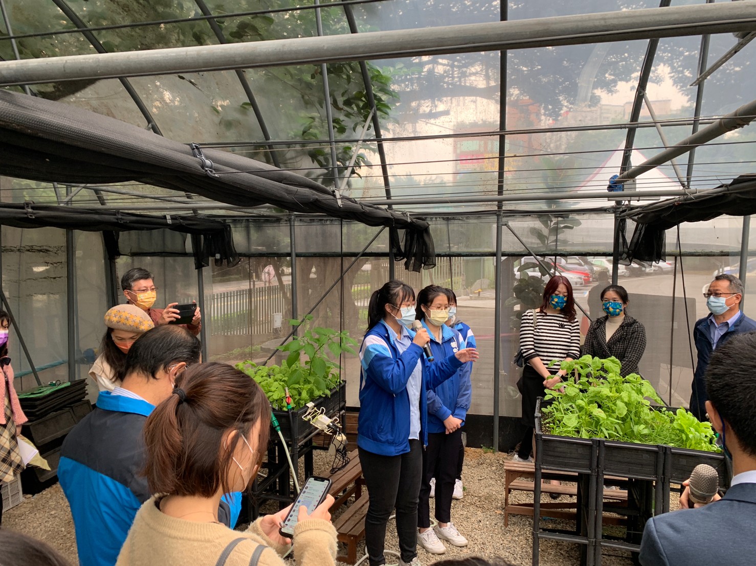 本場傅仰人副場長 (右1)參加板橋高中食育實驗室開幕活動，學生介紹校園一米菜園。圖/李瑞婷老師提供