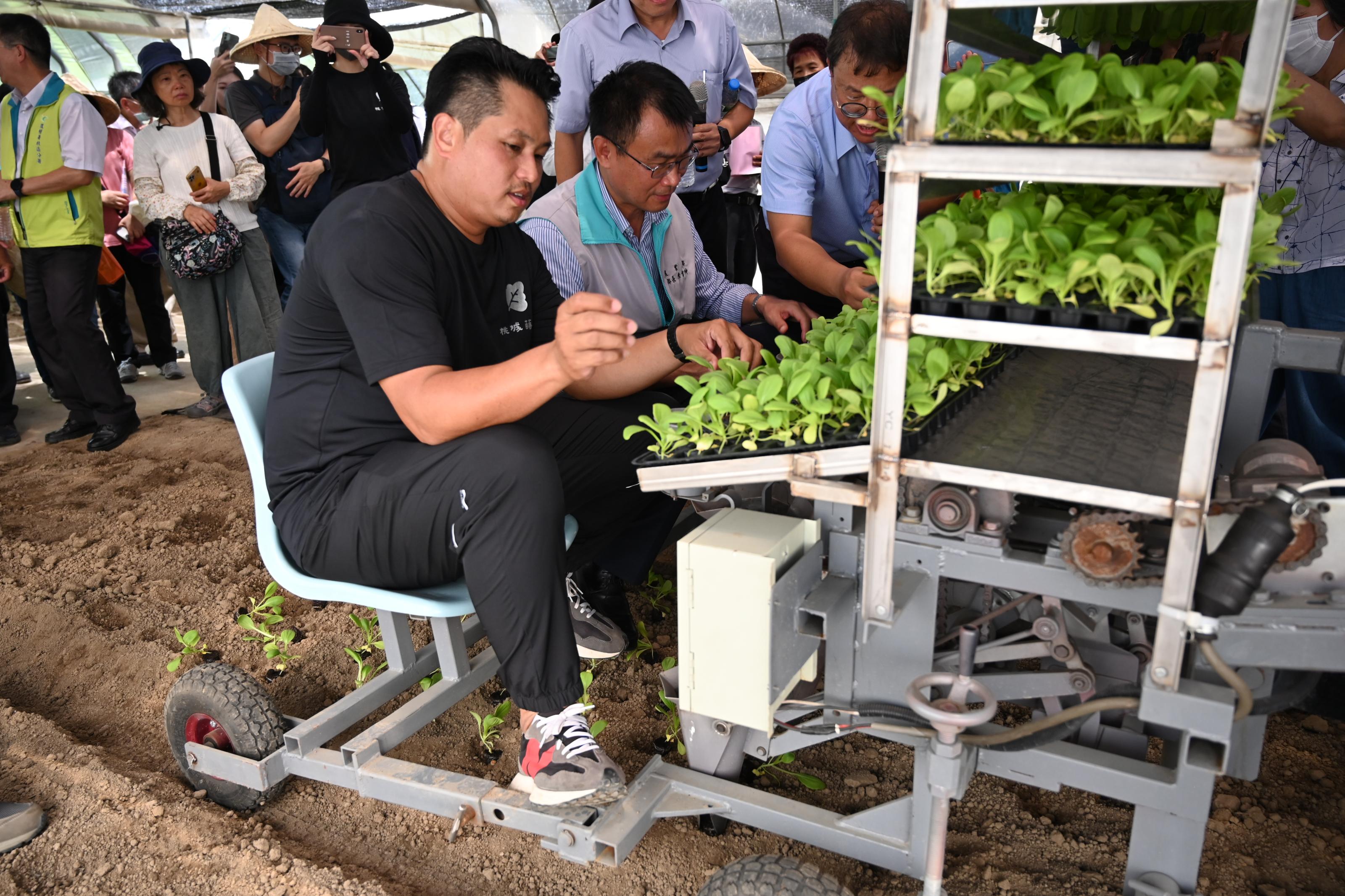 農業部陳吉仲部長與邱冠鈞場長操作葉菜可變行株距移植機